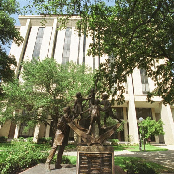 statue and building on campus